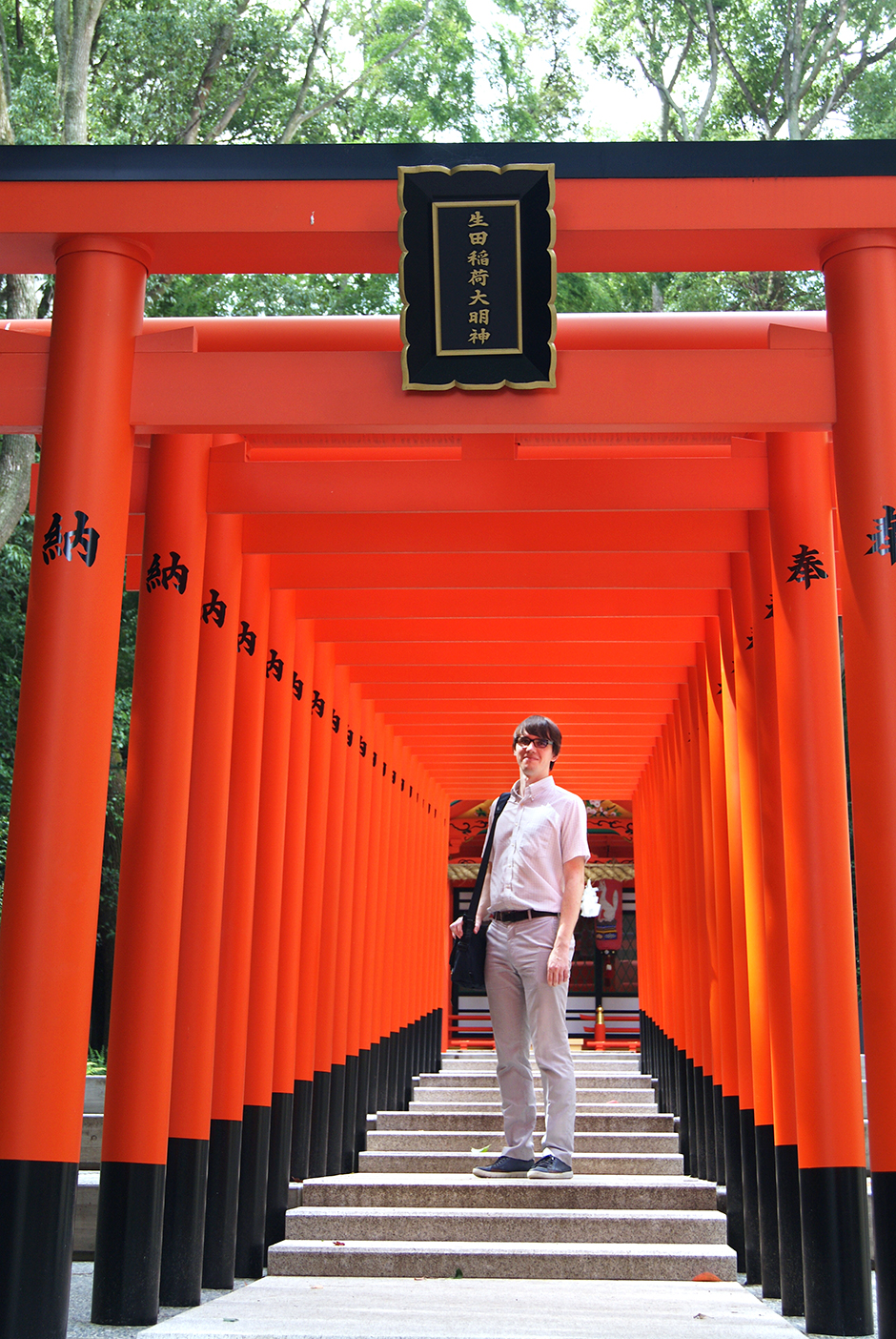You don't need to go to Kyoto to take a photo like this. There's a short path of bright red tori gates right behind Ikuta shrine.